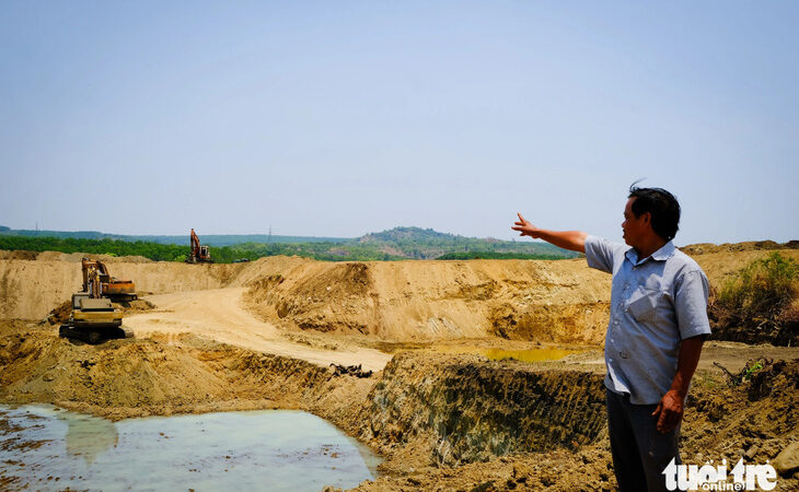 Nông dân Hoàng Văn Chọn bên cái ao rộng hơn 1ha đang đào làm nơi chứa 140.000m3 nước - Ảnh: TẤN LỰC