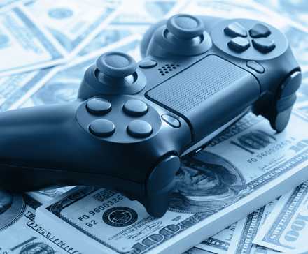 A PlayStation 4 controller on top of a pile of cash.